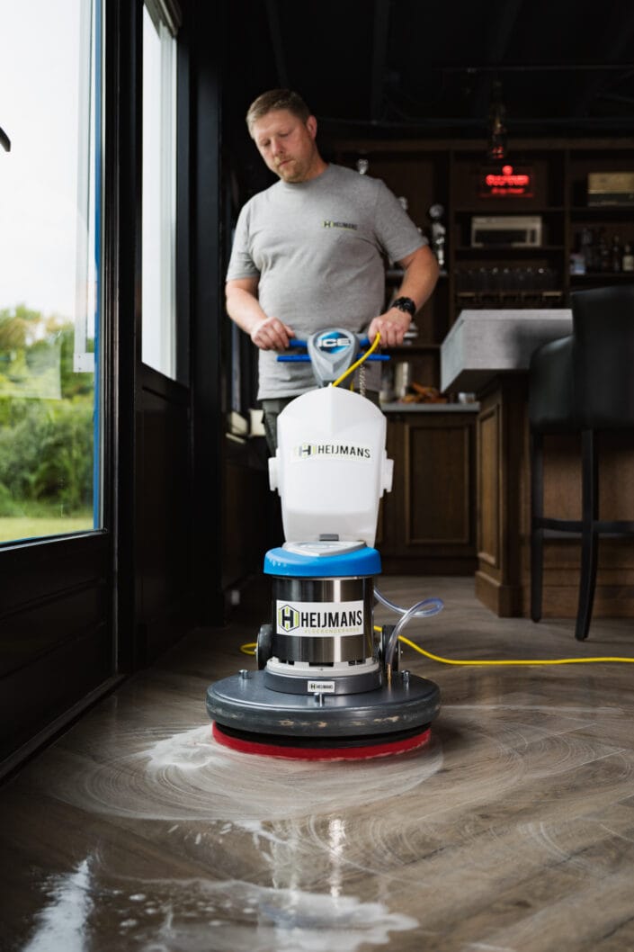Professionele vloerreiniging met schrobmachine in horecaomgeving door Heijmans Vloeronderhoud