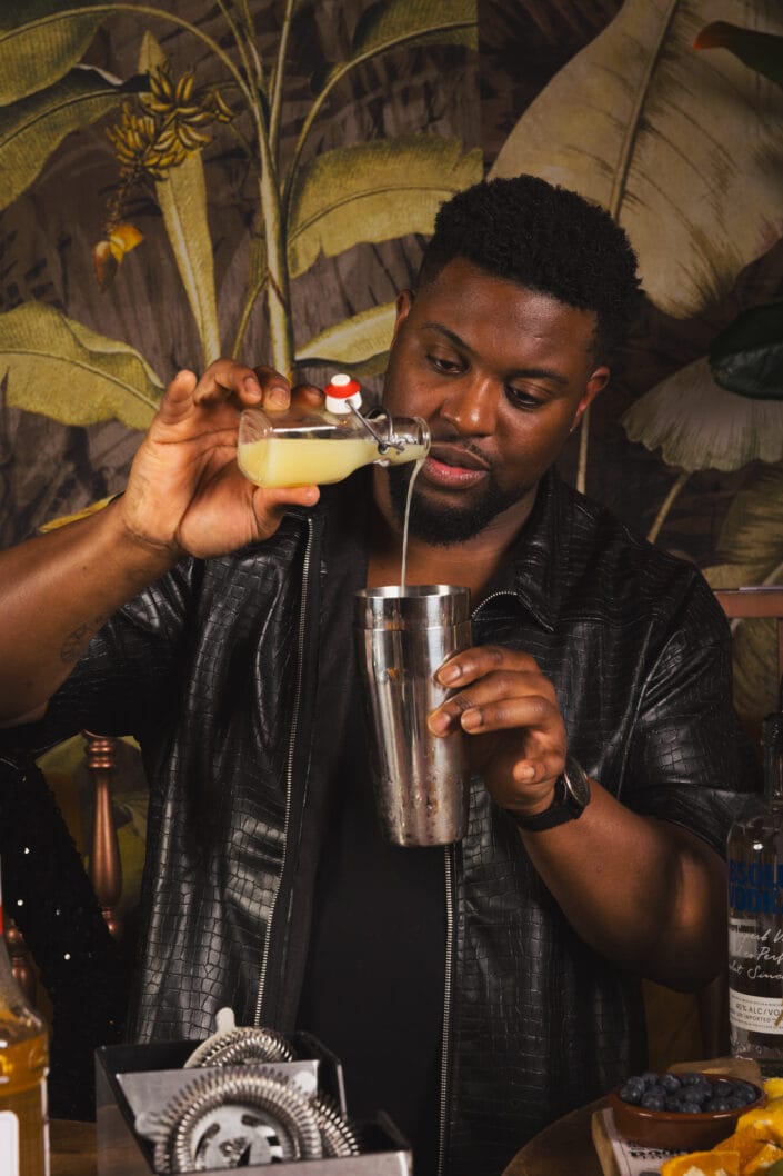 Man schenkt limoensap in shakebeker.