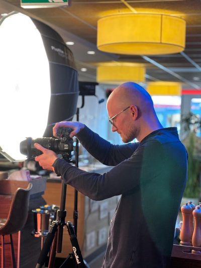 Fotograaf met camera en flitslamp in restaurant setting